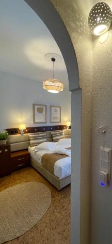 a bedroom with a large bed and a chandelier at Semiramis Guesthouse in Adamas