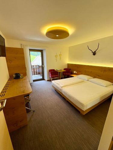 a hotel room with a bed and a table at Garni Apparthotel St Valentin in San Valentino alla Muta