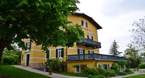 a yellow building with black balconies on it at Hotel Seehof in Maria Wörth