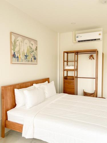 a bed in a room with a white bedvisor at no 185 hostel in Ban Pak Nam Pran