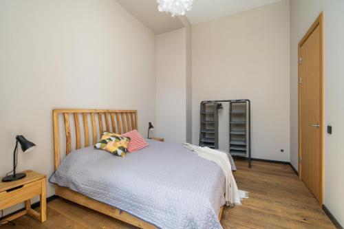 a bedroom with a bed with a wooden headboard at Apartments with private parking & terrace in Jūrmala