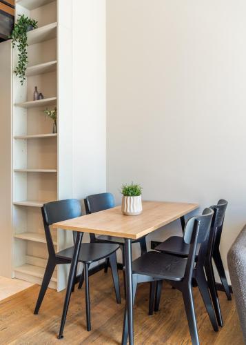 a dining room table with black chairs around it at Apartments with private parking & terrace in Jūrmala