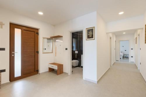 a hallway with white walls and a wooden door at Villa Eni by Istrialux in Žminj