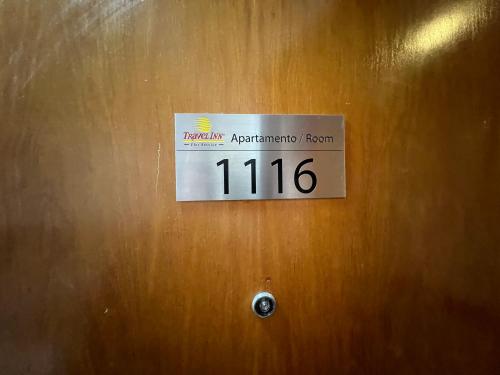 a sign on a wooden door with the number at Hotel Live Logde Pq Ibirapuera UH-1116 in Sao Paulo