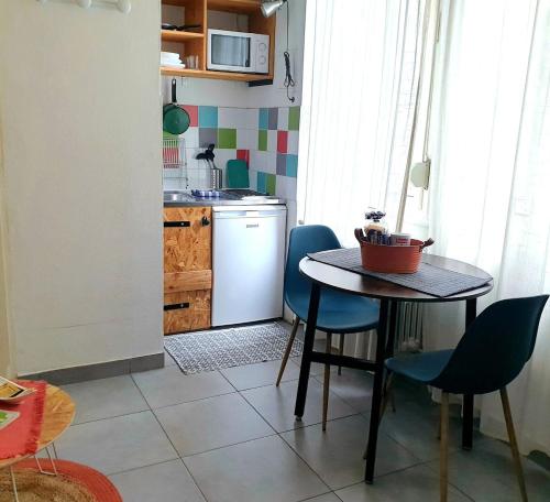 une cuisine avec une table et des chaises bleues dans une cuisine dans l'établissement Studio Aurélie Breakfast et proche centre historique, à Strasbourg