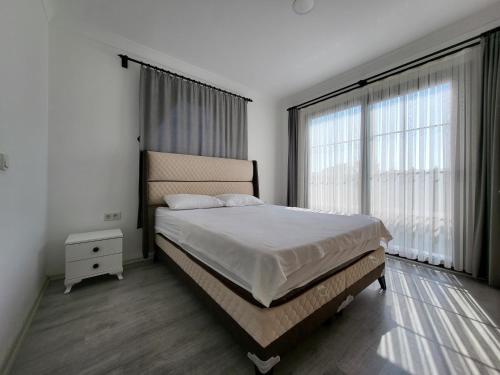a bedroom with a bed and a large window at Villa Da London in Dalaman