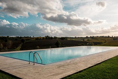 a swimming pool in the middle of a field at Borgo Syrah in Cortona