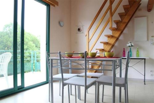 une salle à manger avec une table et des chaises et un escalier dans l'établissement Studio mezza - La Rochelle - LR020-328, à La Rochelle