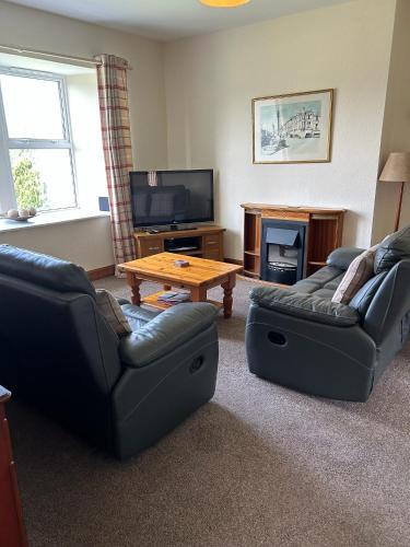 a living room with two couches and a coffee table at Martinshouse Holiday Cottage, Hawick, Borders in Hawick