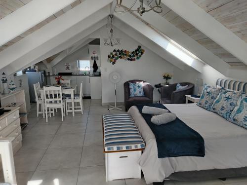 a bedroom with a large bed and a kitchen at The Loft on Malmok in Paternoster