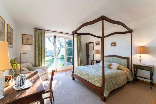 une chambre avec un lit à baldaquin et un bureau dans l'établissement Magical villa 14 pers pool Clim, à La Môle