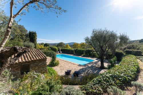 une piscine dans un jardin avec une maison en pierre dans l'établissement Magical villa 14 pers pool Clim, à La Môle