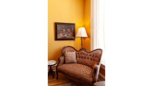 a living room with a chair and a lamp at Mary Lambert - Historic Hotel in Cimarron