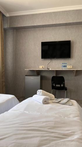 a hotel room with a bed and a flat screen tv at Hotel Oasis in Kapan