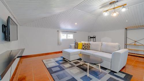 a living room with a white couch and a table at Family House in Campanário