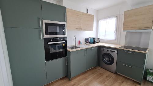 une cuisine avec un réfrigérateur, un évier et un lave-vaisselle dans l'établissement Belle vue sur Dijon, à Dijon