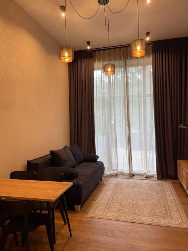 a living room with a couch and a table at Apartments with private parking & terrace in Jūrmala