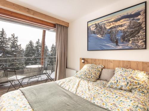 a bedroom with a bed and a balcony with a view at Très bel appartement exposition sud classé 3 étoiles in Chamrousse
