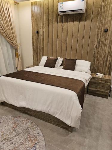 a bedroom with a large bed with a tv on the wall at بلو هيفن in As Sayl aş Şaghīr