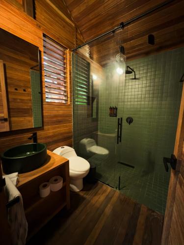 a bathroom with a shower and a toilet and a sink at Solana Mar y Selva Boutique in Bahía Solano