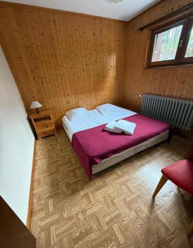 une chambre avec un grand lit avec une couverture rose dans l'établissement Borée, à Thollon-les-Mémises