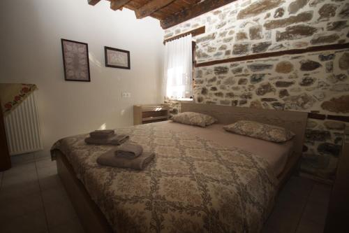 a bedroom with a bed and a stone wall at Anna Cozy Corner in Agios Nikolaos