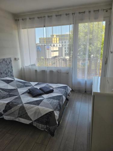 une chambre avec un lit et une grande fenêtre dans l'établissement F2 avec grand balcon quartier gare!, à Metz