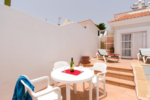 eine Terrasse mit einem Tisch und Stühlen sowie einer Flasche Wein in der Unterkunft Tranquil 4 Bedroom Holiday Villa in Callao Salvaje