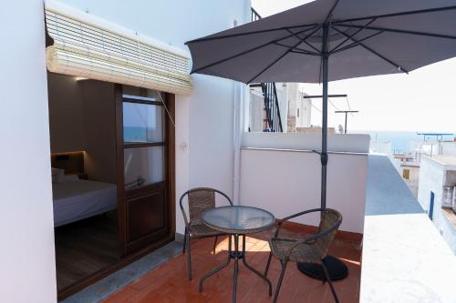 a table and two chairs and an umbrella on a balcony at Casa Castell Orangecosta in Peñíscola