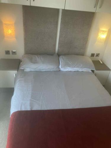 a large bed in a room with two pillows at Billing Aquadrome Holiday Park in Great Billing
