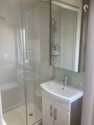 a white bathroom with a sink and a shower at Billing Aquadrome Holiday Park in Great Billing