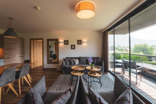 a living room with a couch and a table at Schönblick Residence Apartments - including summer & mobility card in Zell am See
