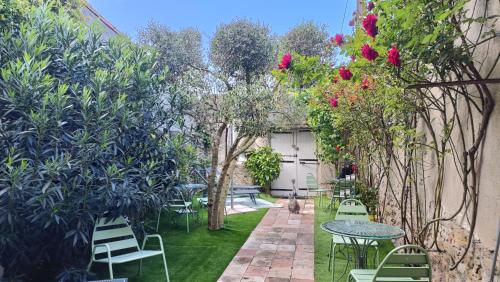 a garden with tables and chairs and flowers at Une bulle de bien être au rendez vous in Pexiora