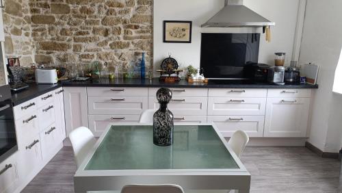 a kitchen with a glass table with a vase on it at Une bulle de bien être au rendez vous in Pexiora
