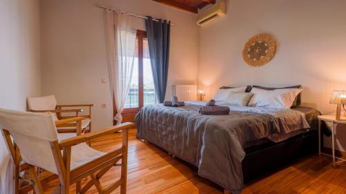 a bedroom with a bed and a chair and a window at To Rodi in Corfu Town