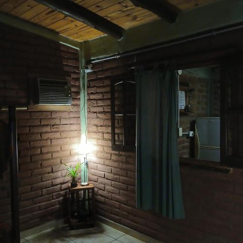 a light in a room with a brick wall at Posada & Hostel La Soñada in Chilecito