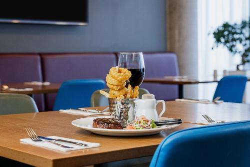 a table with a plate of food and a glass of wine at Holiday Inn Express Aberdeen Airport by IHG in Dyce