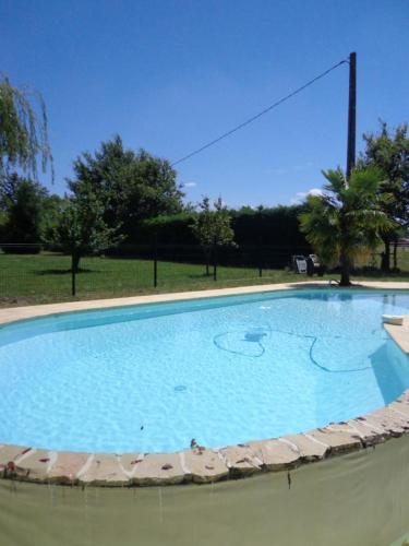 une grande piscine bleue dans un parc dans l'établissement Bergerie de laugeron 1, à Benquet