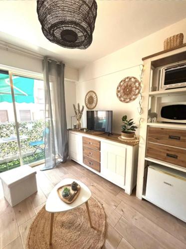 un salon avec une table et une cuisine dans l'établissement Charming studio for two with balcony in Antibes, à Antibes