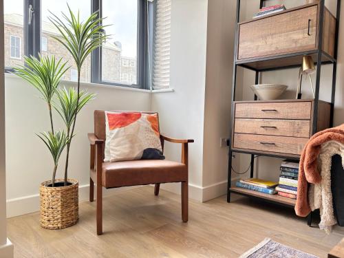 a living room with a chair and a plant at Kerensa 3 bed townhouse located close to the beach with Parking in Penzance