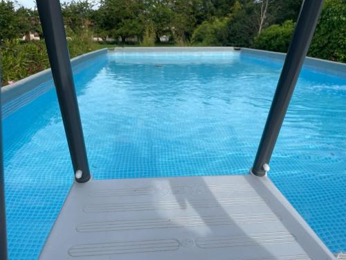 une vue d'une piscine à travers une fenêtre dans l'établissement Maison à la campagne avec piscine hors sol, à Saint-Germain-Nuelles
