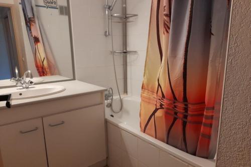 une salle de bain avec un lavabo et un rideau de douche dans l'établissement Coquet T2 Mezzanine - Diamant 95, à Canet