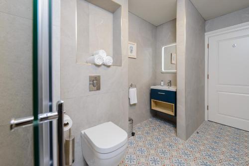 a bathroom with a white toilet and a sink at Dingle Heritage Townhouse in Dingle