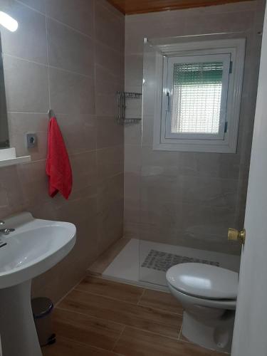 a bathroom with a sink and a toilet and a window at Casa Valeriana Guijosa in Guijosa