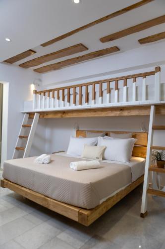 a bedroom with a bunk bed with a ladder at Studios Stratos in Naxos Chora
