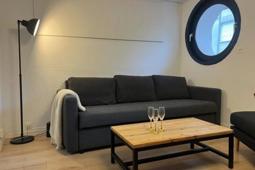 - un salon avec un canapé et une table avec des verres à vin dans l'établissement Cosy apartment in Le Touquet, à Le Touquet-Paris-Plage