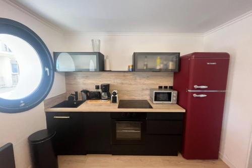 La cuisine est équipée d'un réfrigérateur rouge et d'un évier. dans l'établissement Cosy apartment in Le Touquet, à Le Touquet-Paris-Plage