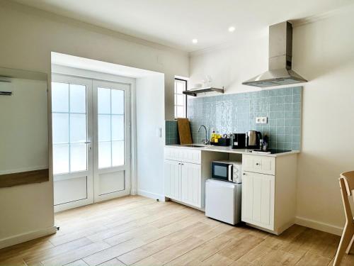 a kitchen with white cabinets and a white refrigerator at Casa Martins Country Apt 8 - Courtyard and pool in Freiria