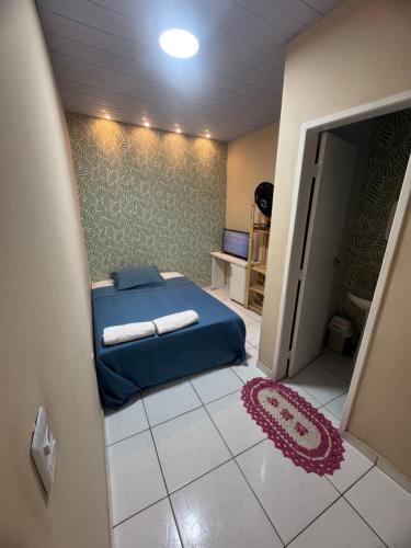 a bedroom with a blue bed and a carpet at Suite climatizada em Ap compartilhado na ponta da areia in Vinhais