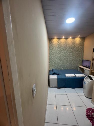 a bedroom with a blue bed in a room at Suite climatizada em Ap compartilhado na ponta da areia in Vinhais
